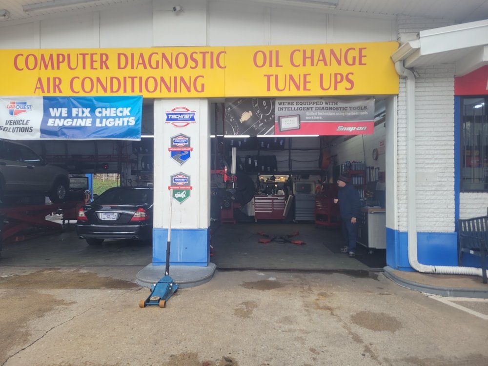 Open repair bays with computer diagnostic and oil change signs at Thompson Lane Auto